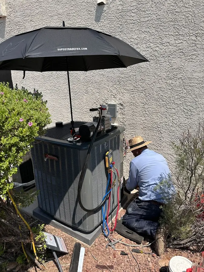 HVAC technician performing outdoor AC maintenance in Greenbriar