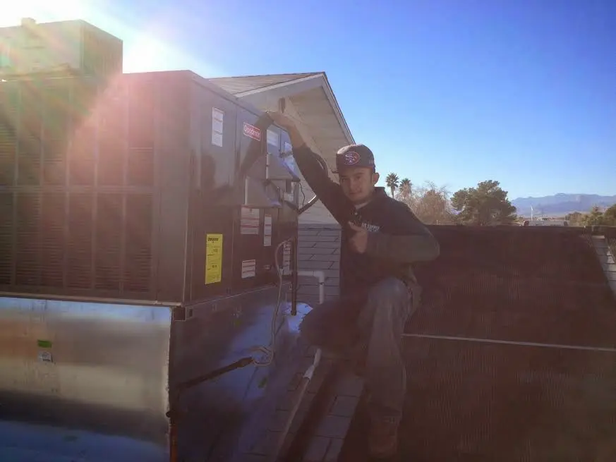 HVAC technician performing AC Tune-Up on a rooftop unit in Greenbriar